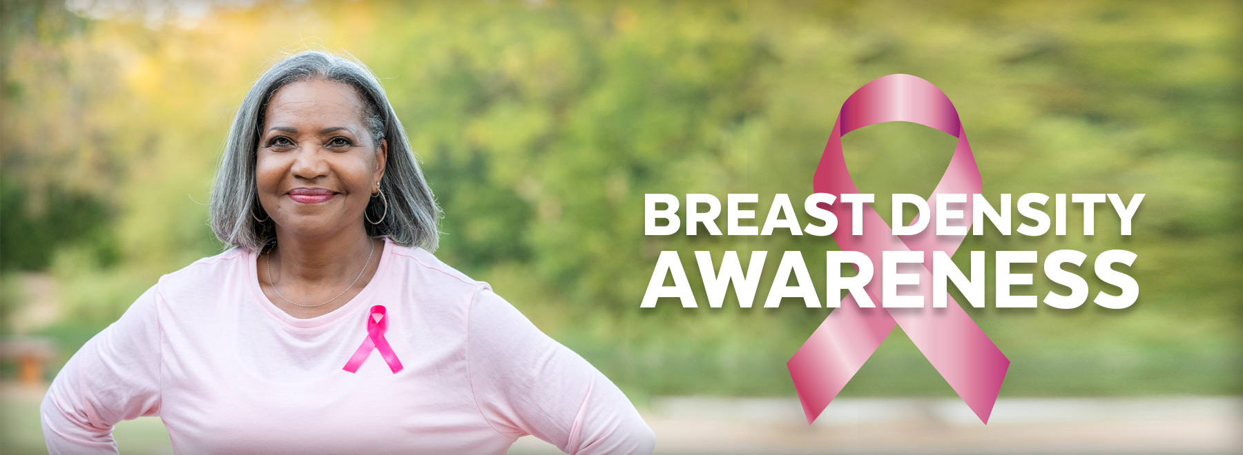Photo of African american woman with pink shirt and breast cancer ribbon on it.
